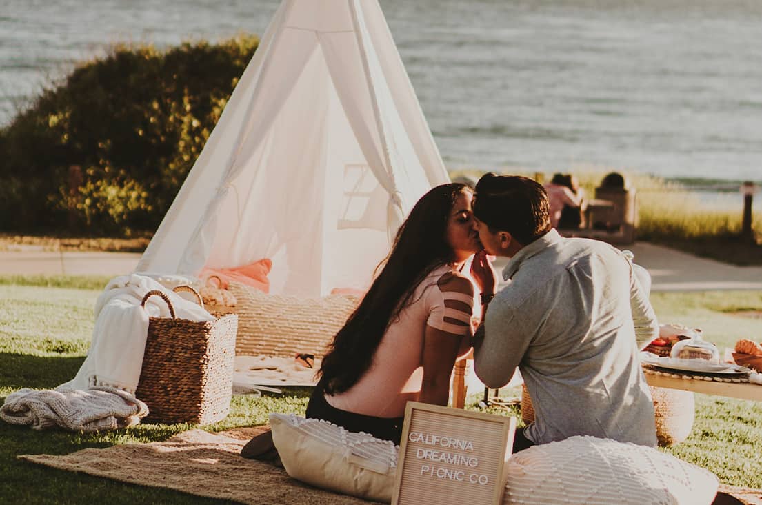 Boy and girl kissing at a picnic