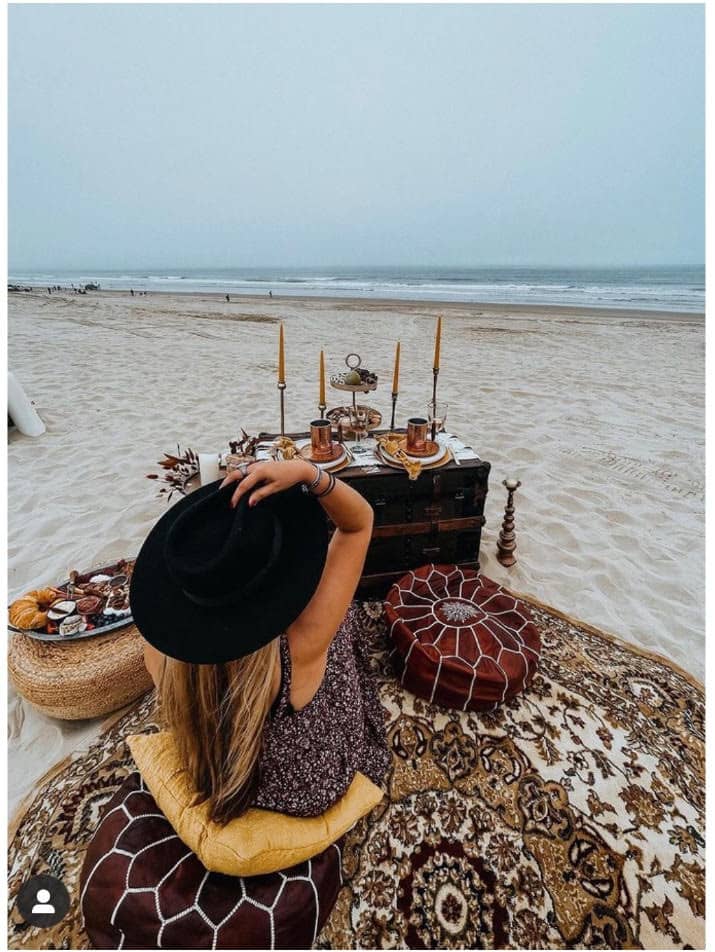 girl sitting on a rug at the beach